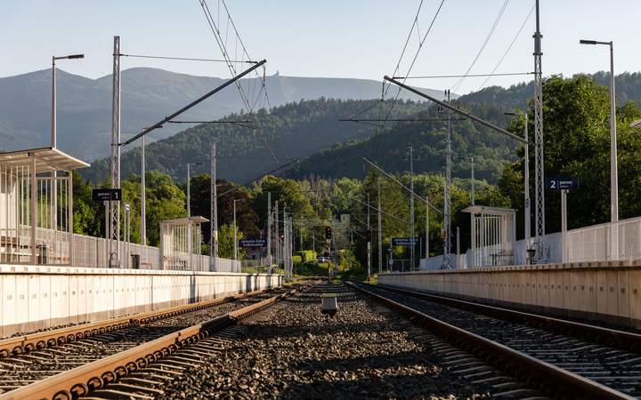 Voies ferrées électrifiées s’éloignant vers les montagnes