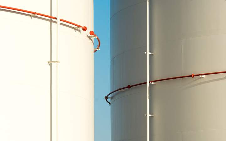 Réservoirs de stockage cylindriques blancs sous un ciel bleu