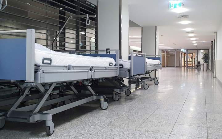 Lits d’hôpital médicalisés alignés dans un long couloir lumineux