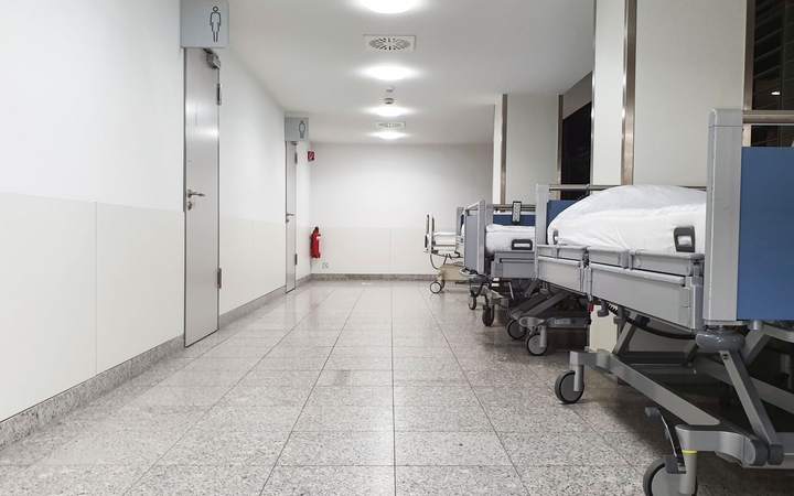 Couloir d’hôpital avec lits médicalisés alignés le long du mur