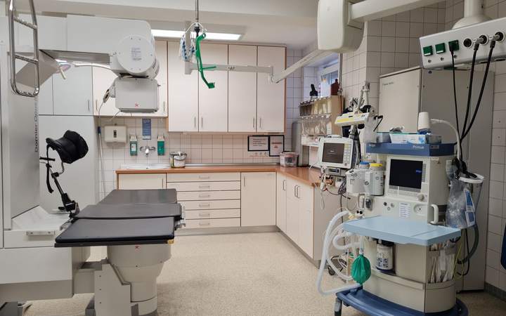 Salle d’intervention hospitalière avec table, bras articulés et appareil d’anesthésie