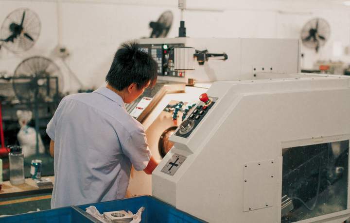 Opérateur réglant une machine-outil dans un atelier de production