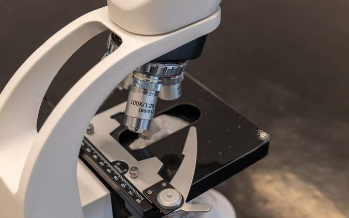 Gros plan sur les objectifs et la platine d’un microscope optique de laboratoire
