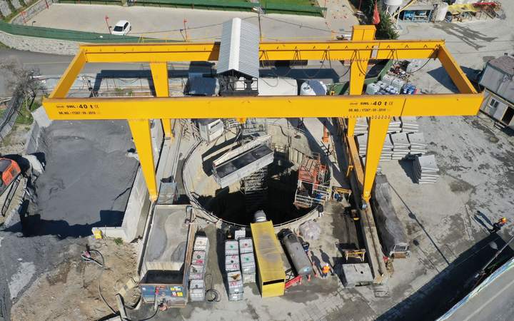Portique jaune au-dessus d’un puits de tunnelier sur un chantier de travaux souterrains