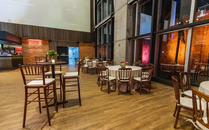 Espace de restauration d’un établissement recevant du public avec tables hautes et baies vitrées
