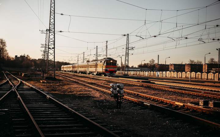Faisceau de voies ferrées et caténaires dans une gare de triage au soleil couchant