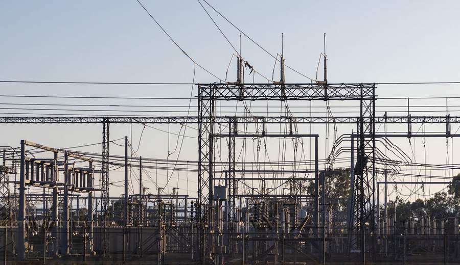 Poste électrique haute tension à l’aube, structures métalliques et lignes