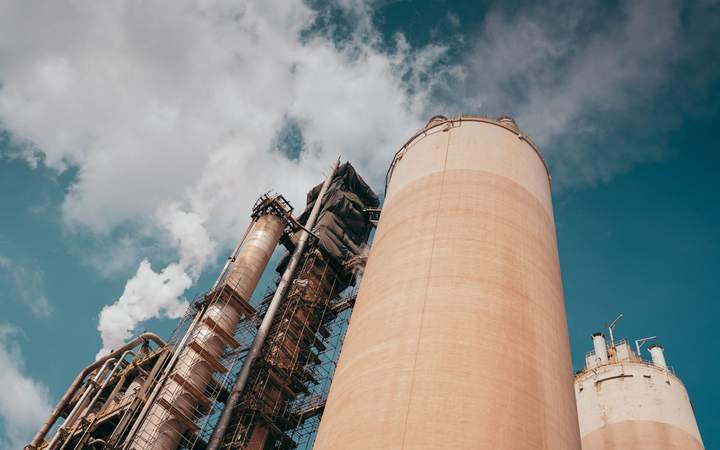Silo industriel et tour de process vus en contre-plongée sous les nuages