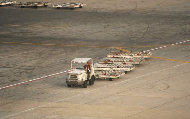 Tracteur de piste tirant des chariots à bagages sur le tarmac