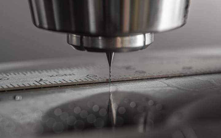 Outil de coupe d’une machine à commande numérique au-dessus d’une plaque métallique