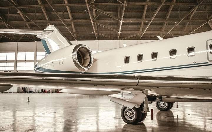 Avion d’affaires stationné dans un hangar de maintenance au sol brillant