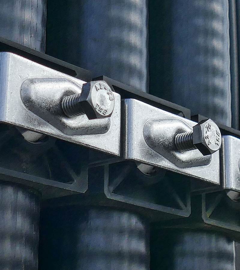 Colliers de fixation boulonnés maintenant de gros câbles électriques gainés noirs
