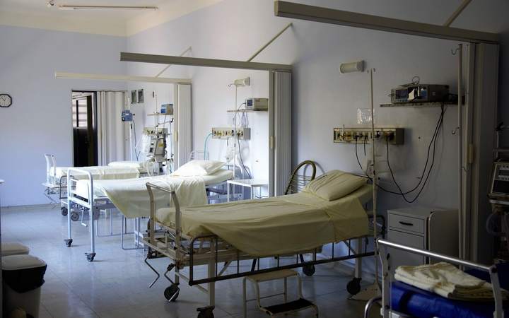 Chambre d’hôpital collective avec lits médicalisés vides et rampes de fluides murales