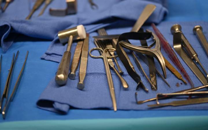 Instruments chirurgicaux en acier disposés sur un champ stérile bleu