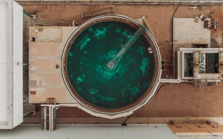 Vue aérienne d’un bassin de décantation circulaire dans une installation de traitement des eaux industrielles