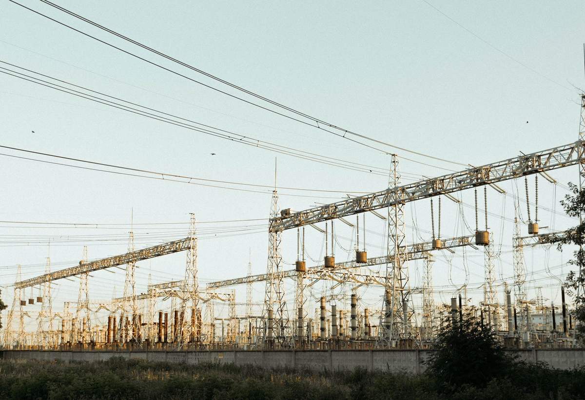 Poste électrique haute tension et portiques de lignes aériennes en pleine campagne