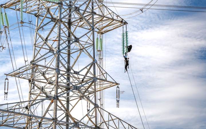 Pylône et lignes haute tension avec un technicien en ascension