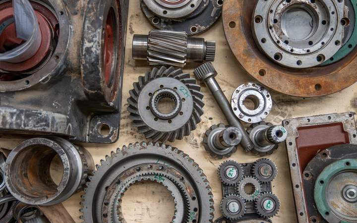 Engrenages, roulements et pièces mécaniques démontés sur un établi