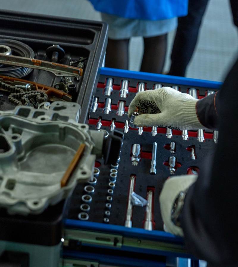 Mains gantées choisissant une douille dans une servante d’outillage lors d’une opération de maintenance