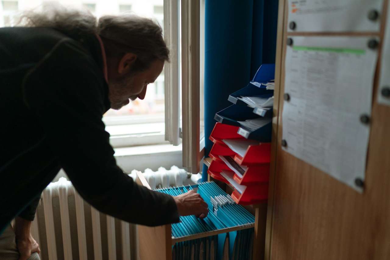 Agent triant le courrier dans des casiers de rangement d’un bureau administratif