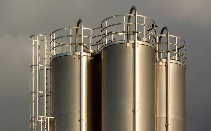 Silos en inox avec échelles et garde-corps sous un ciel gris