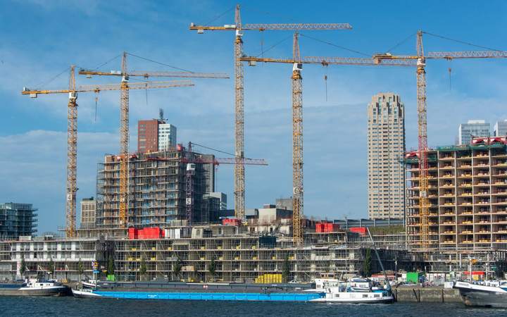 Grues et immeubles en construction au bord d’un fleuve