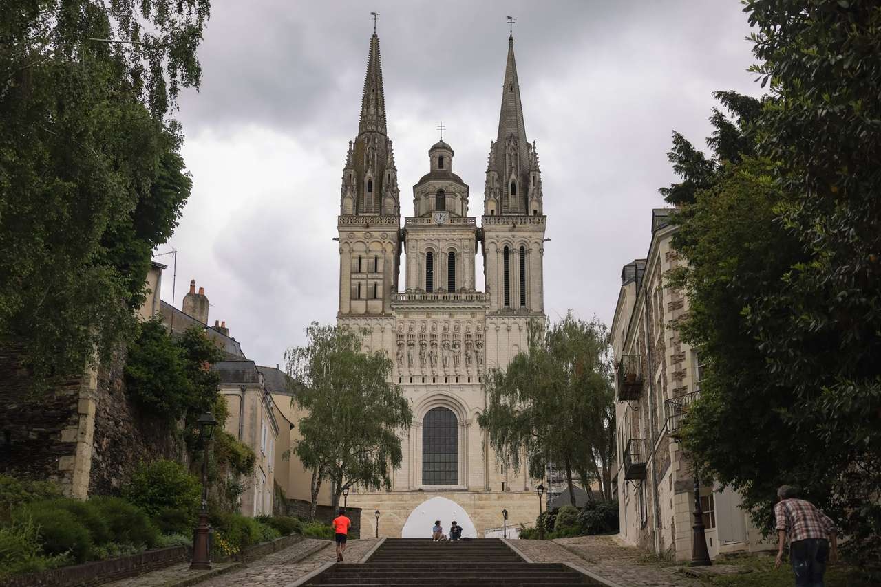 Façade et flèches de la cathédrale Saint-Maurice d’Angers, au sommet d’une montée d’escaliers bordée d’arbres