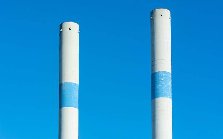 Deux cheminées industrielles blanches cerclées de bleu, sur un ciel dégagé