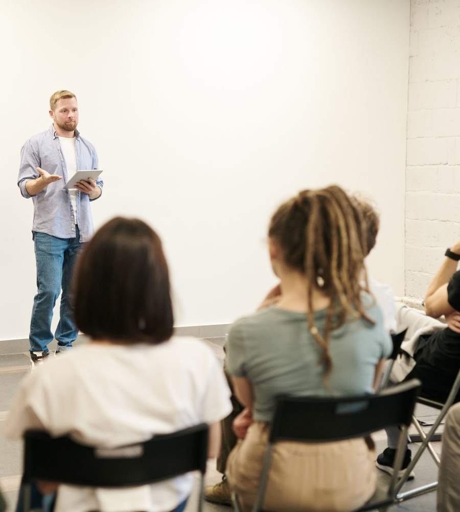 Formateur s’adressant à un groupe de stagiaires dans une salle claire