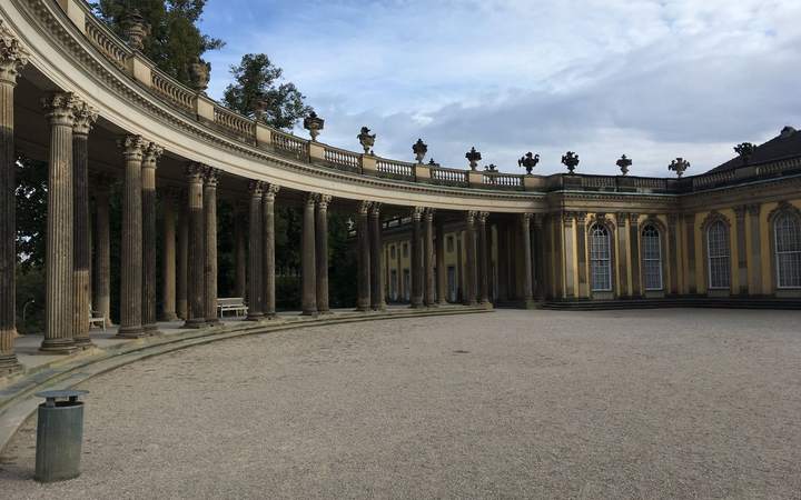 Colonnade en arc de cercle devant la façade d’un palais