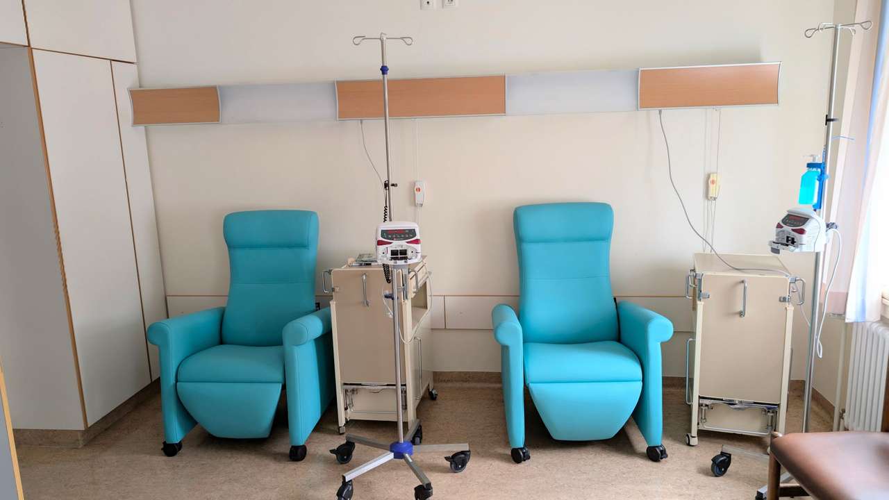 Salle de soins avec fauteuils de traitement turquoise et pieds à perfusion