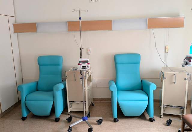 Salle de soins avec fauteuils de traitement turquoise et pieds à perfusion