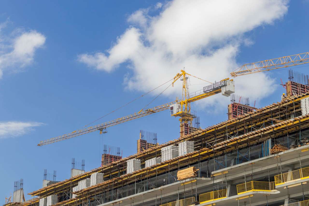 Immeuble en construction et grue de chantier sous un ciel bleu