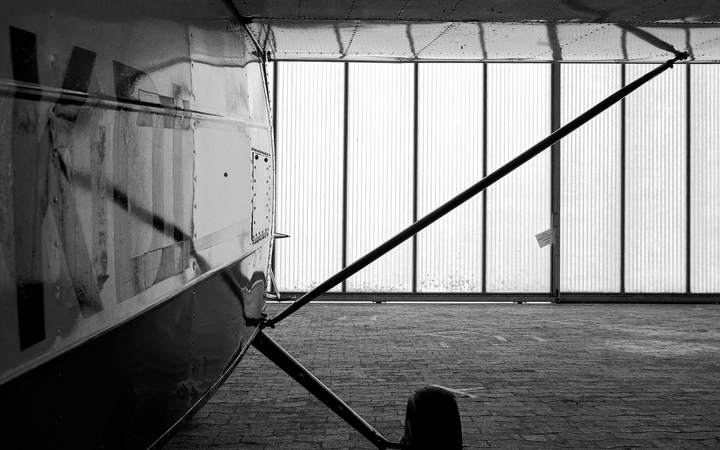 Fuselage et train d’atterrissage d’un avion léger dans un hangar, en noir et blanc