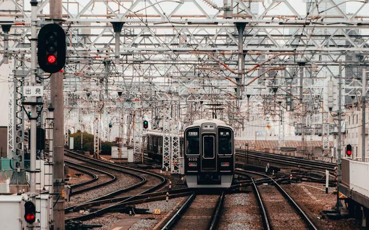 Train de banlieue entrant dans une gare sous les caténaires
