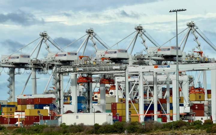 Portiques de manutention alignés au-dessus des conteneurs d’un terminal portuaire