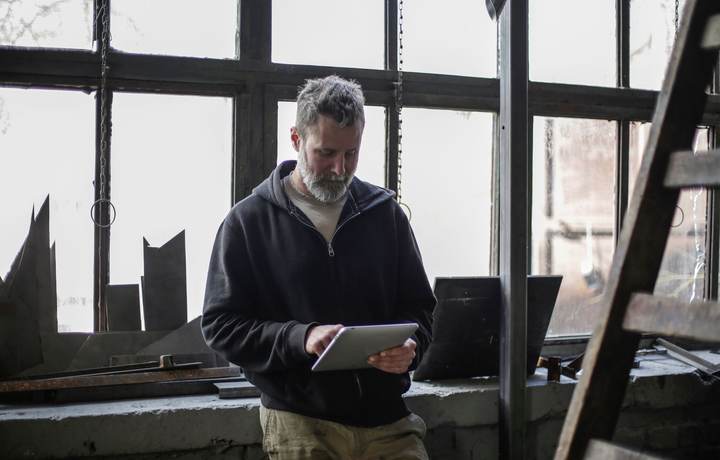 Artisan indépendant consultant une tablette dans son atelier