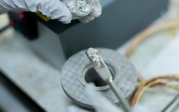 Mains gantées préparant un échantillon dans un laboratoire