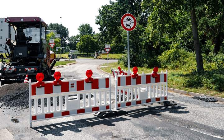 Barrières de chantier et finisseur d’enrobé sur une route fermée pour travaux de réfection