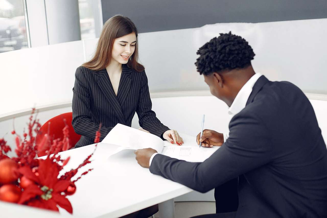 Signature d’un document entre une femme et un homme assis à une table de bureau