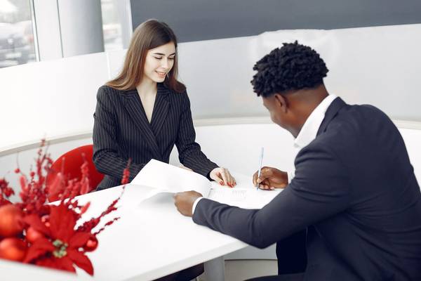 Signature d’un document entre une femme et un homme assis à une table de bureau