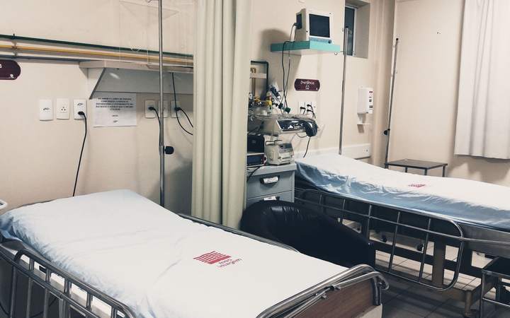 Chambre d’hôpital avec deux lits médicalisés et équipements muraux de soins