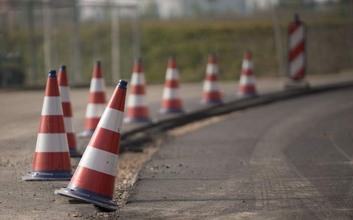Alignement de cônes de signalisation rouges et blancs balisant une voie de chantier routier