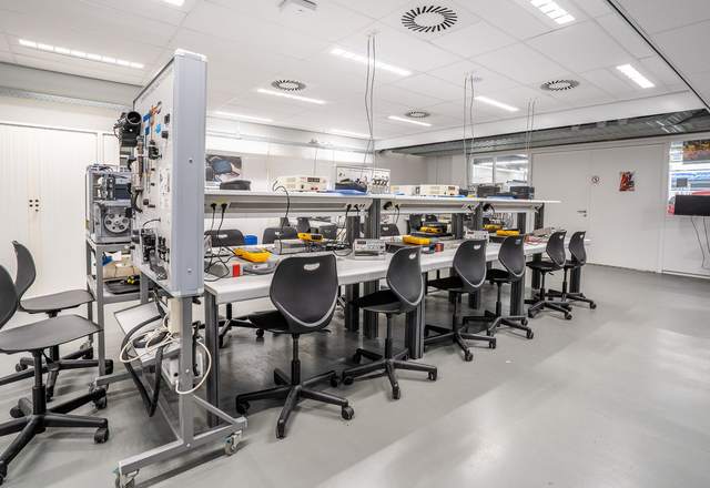 Salle de formation technique équipée de postes de travail et de bancs d’essai électriques