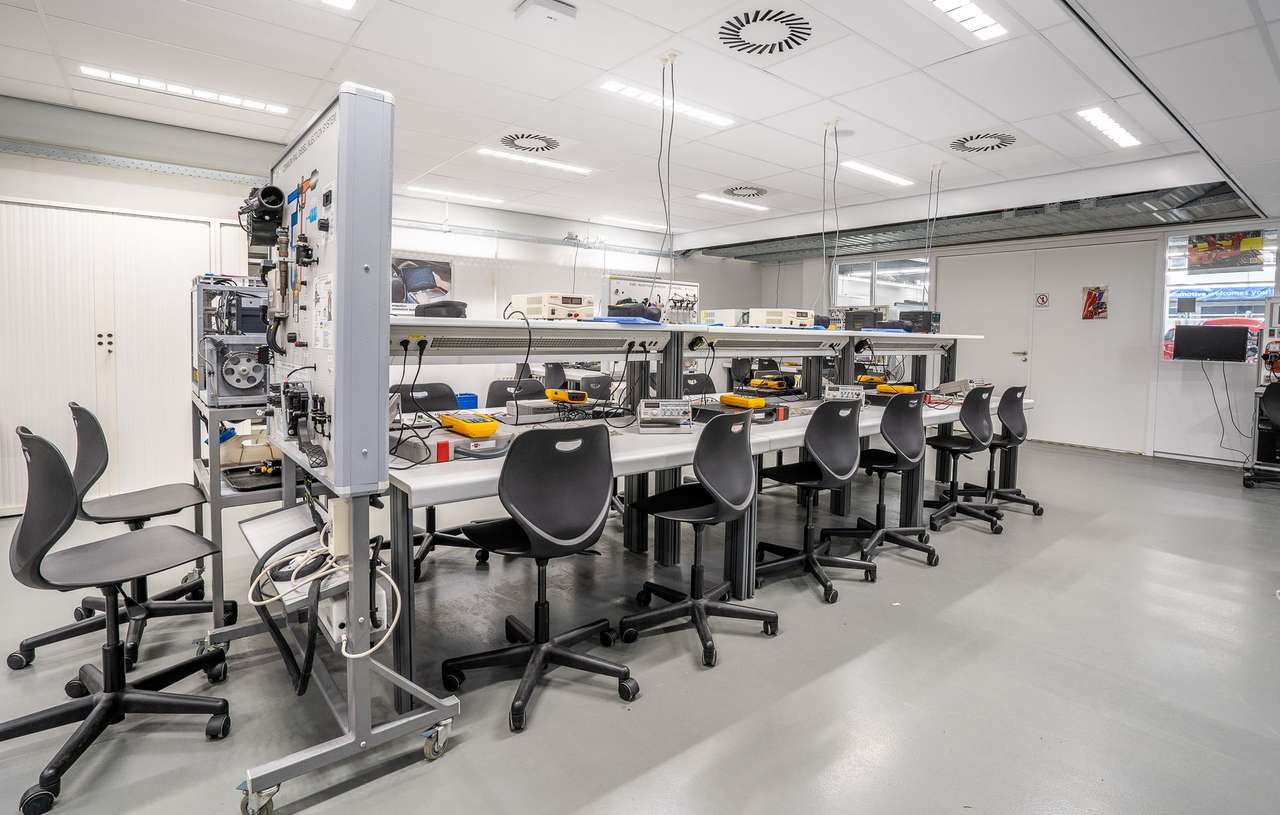 Salle de formation technique équipée de postes de travail et de bancs d’essai électriques