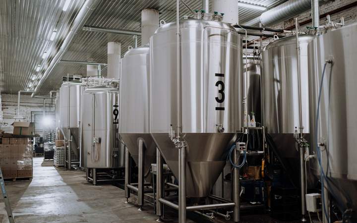 Cuves de fermentation en inox alignées dans une brasserie industrielle
