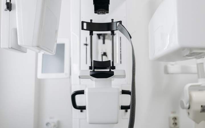 Appareil de radiographie dentaire avec mentonnière et poignées dans une salle blanche