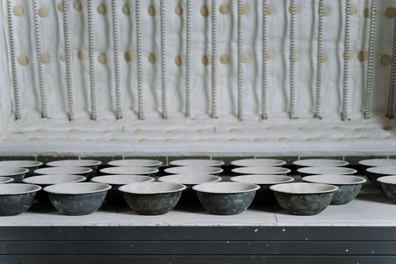 Pièces de céramique disposées dans un four d’atelier, activité emblématique de Limoges