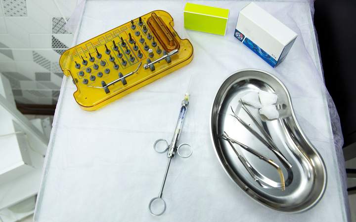 Plateau de soins dentaires avec kit d’implantologie, seringue et haricot en inox