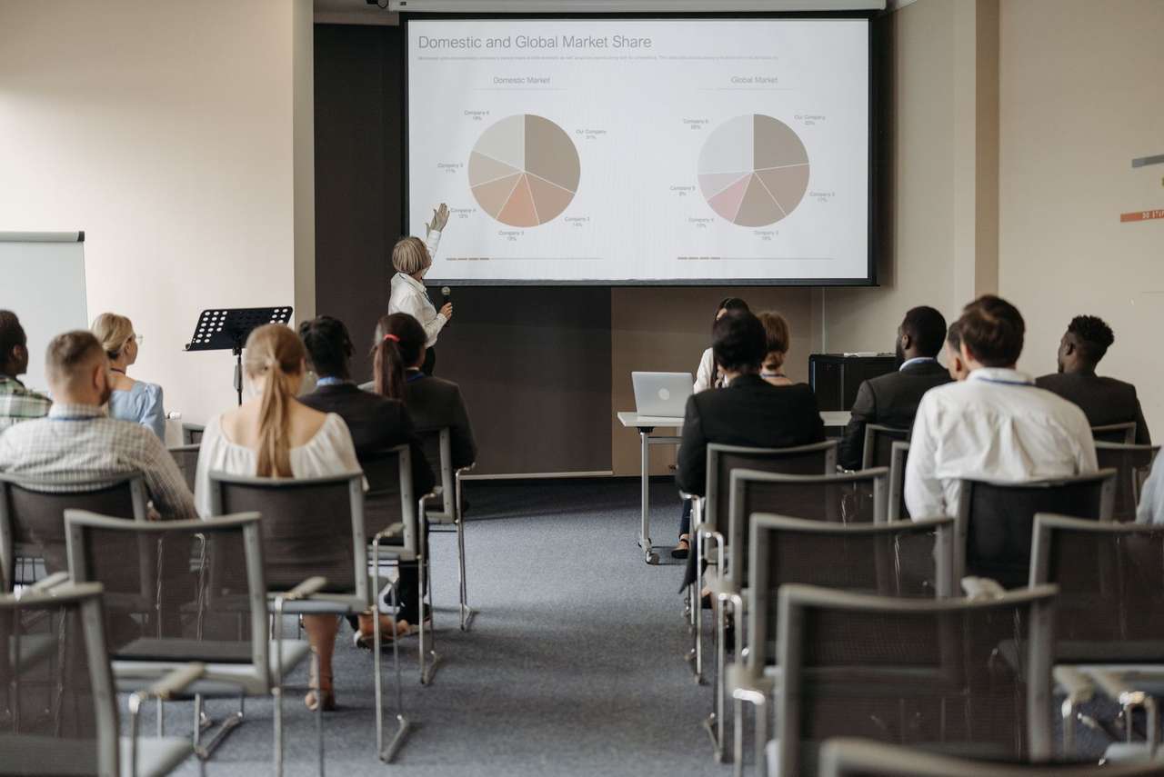 Salle de formation avec participants de dos face à une présentation projetée à l’écran